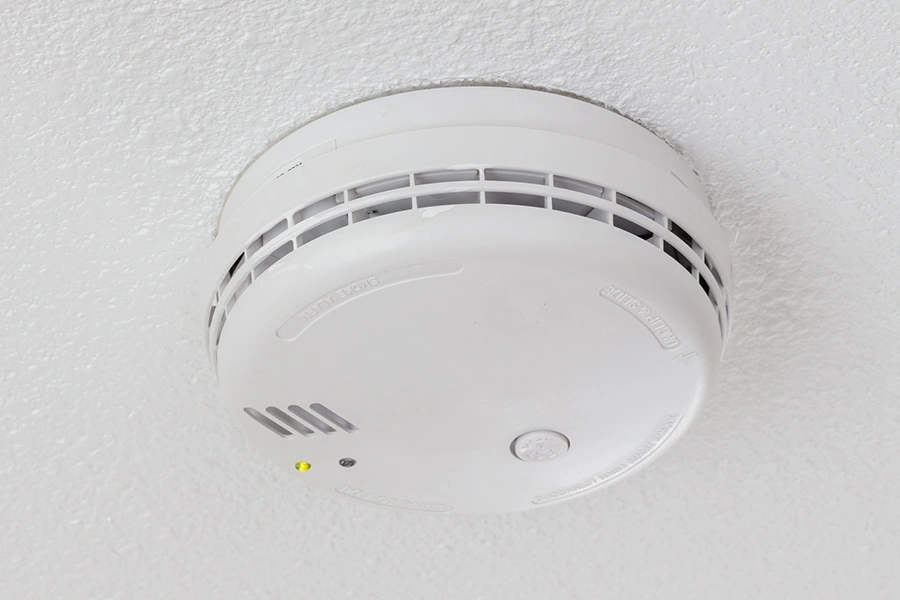 white smoke detector on a white ceiling